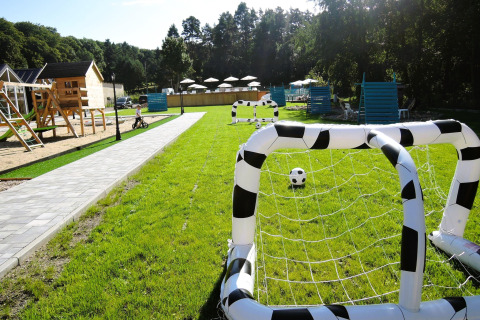Área de juegos verde en Turkusowa osada Wapnica con arcos inflables de fútbol y estructuras de madera.