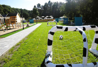 Área de juegos verde en Turkusowa osada Wapnica con arcos inflables de fútbol y estructuras de madera.