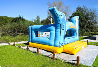 Castillo hinchable azul y amarillo con delfines en Turkusowa osada Wapnica, Alemania, en un día soleado.