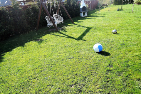 Tuin met hangstoelen, barbecue en ballen bij ‘Peace and quiet - cottage for 4 people’ in Duitsland.