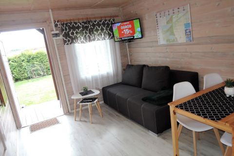 Acogedora cabaña en Alemania para 4 personas, con sofá, comedor, TV y salida al jardín verde y tranquilo.