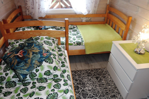 Cozy bedroom in Germany's 'Peace and quiet' cabin, featuring two single beds and leafy bedding.