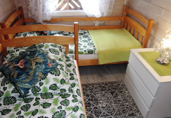 Dormitorio acogedor con dos camas individuales y ropa de cama de hojas en una cabaña en Alemania.