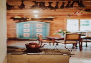 Cozy lodge interior with a copper kettle on a stove, wooden furniture, and a blue painted cabinet behind.
