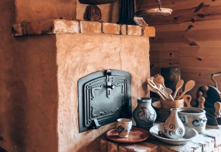 Gezellige keukenhoek in een lodge met een rustieke oven, houten lepels en decoratief aardewerk.