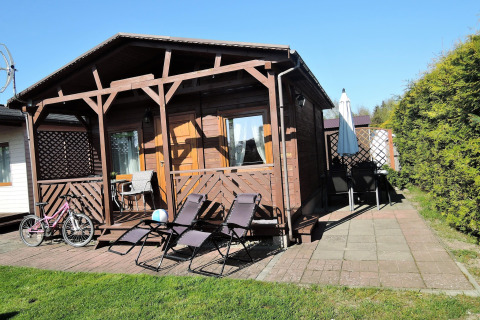 Houten huisje 'Peace and quiet - cottage for 4 people' met ligstoelen en fiets in Duitsland.