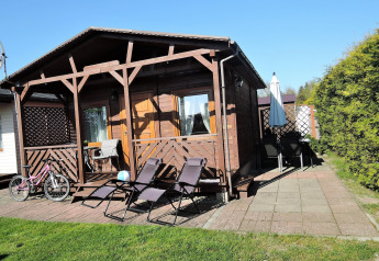 Cabina in legno 'Peace and quiet - cottage for 4 people' con sedie sdraio e bici in Germania.