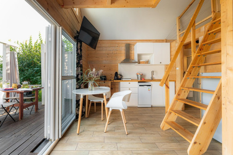 Casa moderna junto al lago Klępnica en Alemania, con cocina, comedor y escaleras de madera a una buhardilla.