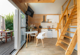 Modern strandhuis bij het meer Klępnica in Duitsland met houten keuken, eethoek en trap naar de slaapzolder.