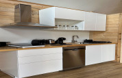 Cocina moderna en casa de playa 'House by Lake Klępnica' en Alemania, muebles blancos y electrodomésticos.
