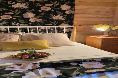 Cozy bedroom at House by Lake Klępnica, Germany, with floral decor and a fruit tray on the bed.