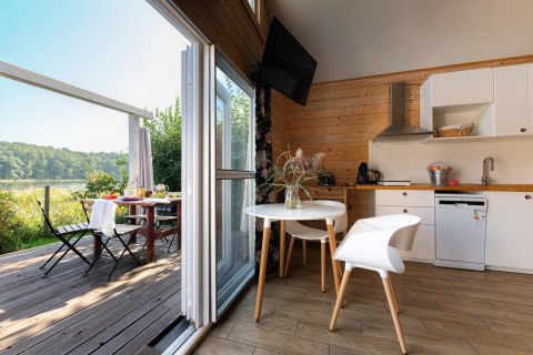 Lichte keuken en eethoek met uitzicht op het terras bij House by Lake Klępnica in Duitsland.
