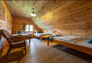 Hyggeligt værelse med tre enkeltsenge og trævægge i House by the road Skansen for 10 personer, Bełczna.
