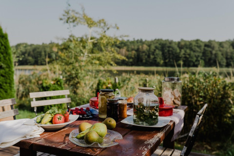 Buiten houten tafel met fruit, groenten en potten bij het Huis aan het meer Klępnica, Duitsland.
