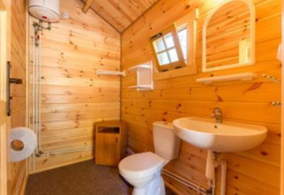 Rustieke houten badkamer met lavabo, toilet en spiegel bij 'Holiday cottages Łazy' in Denemarken.