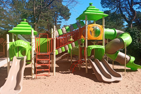Parque infantil con toboganes y techos verdes en Holiday cottages Łazy, ubicado en Dinamarca.
