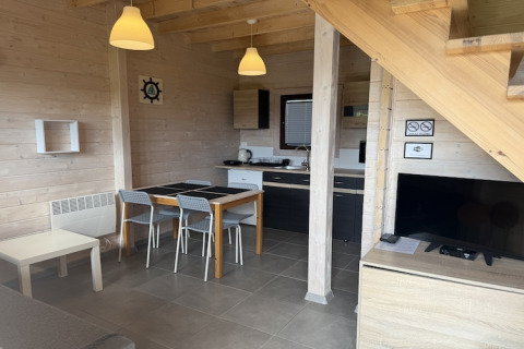 Moderne woon- en keukenhoek in een tweelaags vakantieverblijf in Mielenko, met eettafel en televisie.