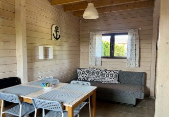 Gezellige leefruimte in een tweelaags vakantiehuis in Mielenko, Denemarken, met tafel en zetel.