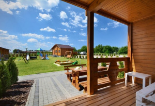 Zicht vanaf de houten veranda van de Mielenko vakantiewoningen met twee verdiepingen en speeltuin in Denemarken.