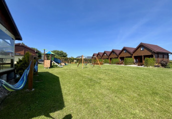 Two-storey holiday cottages for up to 6 people in Mielenko with playground and open grassy area.