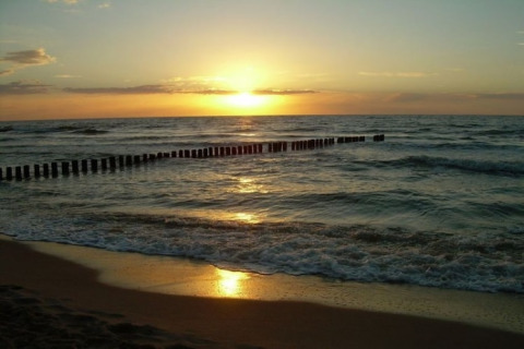 Solnedgang over havet set fra stranden ved Two-storey holiday cottages for max 6 people Mielenko i Danmark.
