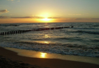 Coucher de soleil sur la mer depuis la plage des Two-storey holiday cottages for max 6 people Mielenko au Danemark.