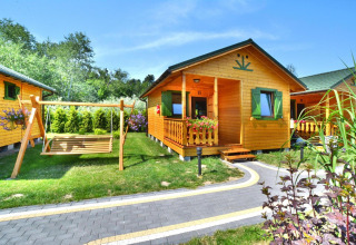 Sommerhäuser für 5 Personen in Mielno, Dänemark, mit Holzveranda, Schaukel und grünem Garten.