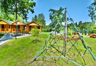 Buitenaanzicht van zomerhuisjes voor 5 personen in Mielno met speeltuin en groene omgeving.