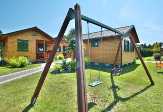 Zomerhuisjes voor 5 personen in Mielno, Denemarken, met houten huisjes en een schommel in de tuin.