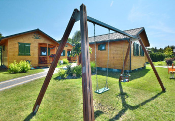 Casas de verano para 5 personas en Mielno, Dinamarca, con columpios y acogedoras cabañas de madera.