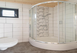 Moderne badkamer met gebogen glazen douche, wandtoilet en raam, Holiday cottages in Gąski, Denemarken.