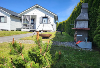 Vakantiehuisje in Gąski, Denemarken, met tuin, barbecue, vuurkorf en tuinstoelen in zonnig weer.