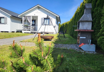 Vakantiehuisje in Gąski, Denemarken, met tuin, barbecue, vuurkorf en tuinstoelen in zonnig weer.
