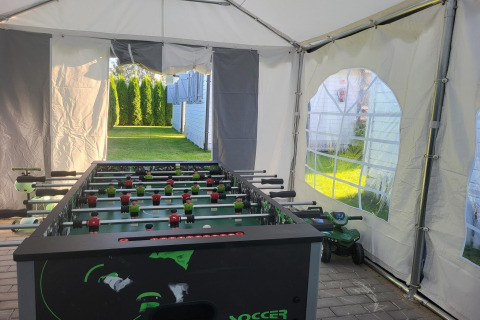 Voetbaltafel in een tent met zicht op de tuin aan de vakantiewoningen in Gąski, Denemarken.