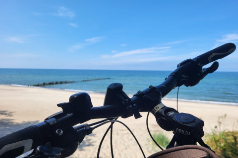 Fietsstuur uitkijkend over strand en zee bij 'Holiday cottages in Gąski' in Denemarken op een zonnige dag.