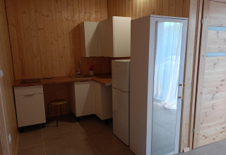 Compact kitchenette with wooden walls at Twin single-storey cottages Jarosławiec lodge in Denmark.