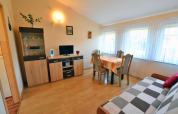 Stue i House in Rosnowo med spisebord, sofa, vitrineskab og store vinduer med gardiner, Danmark.