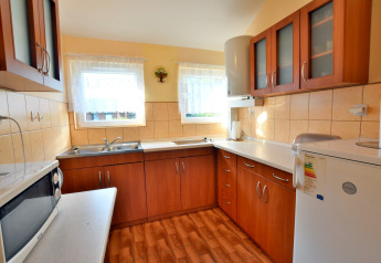 Helles, gemütliches Küche im House in Rosnowo in Dänemark mit Holzmöbeln, Geräten und zwei Fenstern.