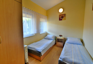 Dormitorio luminoso en House in Rosnowo, Dinamarca, con dos camas individuales y ventana con cortinas.