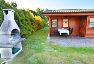 Área exterior de la cabaña "House in Rosnowo" en Dinamarca con barbacoa y terraza con mesa y sillas.