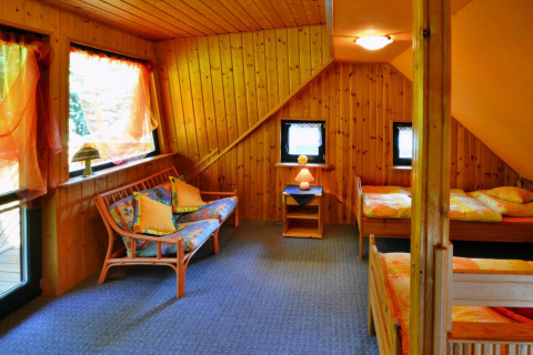 Gemütliches Zimmer im Holiday Home für 3 Personen Kołobrzeg mit Holzwänden und zwei Einzelbetten.