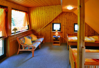 Knusse houten kamer in Holiday home for 3 people Kołobrzeg met twee bedden en gezellige zithoek.
