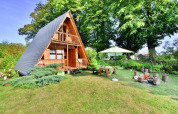 A-frame summer cottage with garden, terrace, fire pit and parasol in lush greenery in Denmark.