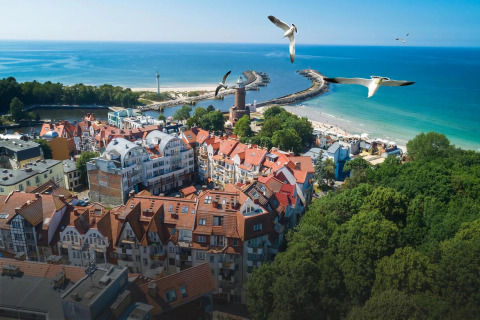 Vista di Kołobrzeg, tetti rossi, porto e spiaggia, dal balcone di una casa per le vacanze.