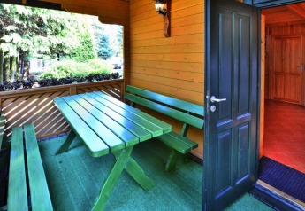 Groene picknicktafel met banken aan het vakantiehuis voor 3 personen Kołobrzeg, zicht op de deur.