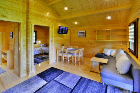 Indvendig udsigt over et træbeklædt glampingindkvartering med moderne møbler og hyggelig atmosfære.