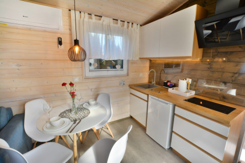Moderne keuken en eetgedeelte in een knusse houten cabin voor twee personen in Ustronie Morskie.