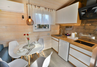 Moderne keuken en eetgedeelte in een knusse houten cabin voor twee personen in Ustronie Morskie.