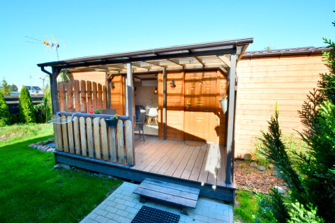 Houten huisje met overdekte veranda en tuin voor twee personen in Ustronie Morskie, Denemarken.