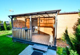 Wooden cabin with covered porch and garden area, ideal for two in Ustronie Morskie, Denmark.